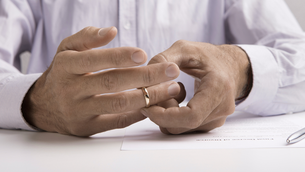 Man removing wedding ring after divorcing